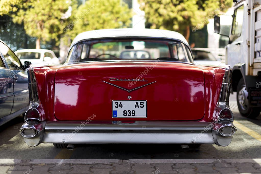 Izmir, Turkey - September 23, 2018: Trunk and Back side logo of a Red 1957 Chevrolet. We see the emblem and the bumper.
