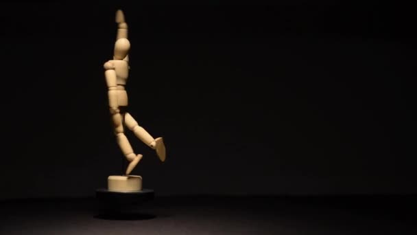 在黑色背景和高对比度上在半空中旋转木制人体模型 — 图库视频影像