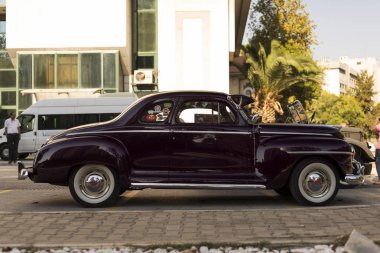 Koyu kırmızı siyah bir 1948 Plymouth Deluxe 'un yan görüntüsü.