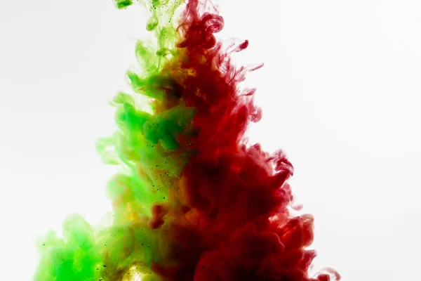 Green and red colored abstract acrylic paint spraiyng on a white — Stock Photo, Image