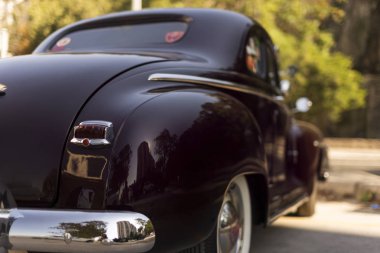 Koyu kırmızı siyah bir Plymouth Deluxe 'un arka görüntüsü.