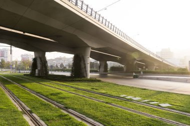 Çimenli tramvay rayları ve karayolu köprüsü.