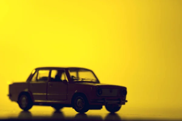 Silhouet speelgoed auto op een levendige rode achtergrond. — Stockfoto