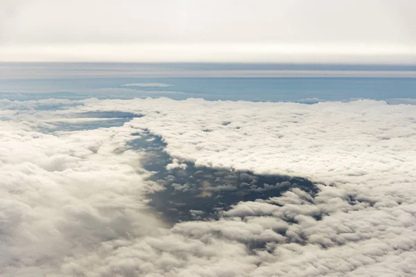 海のある民間機の窓からの雲. — ストック写真