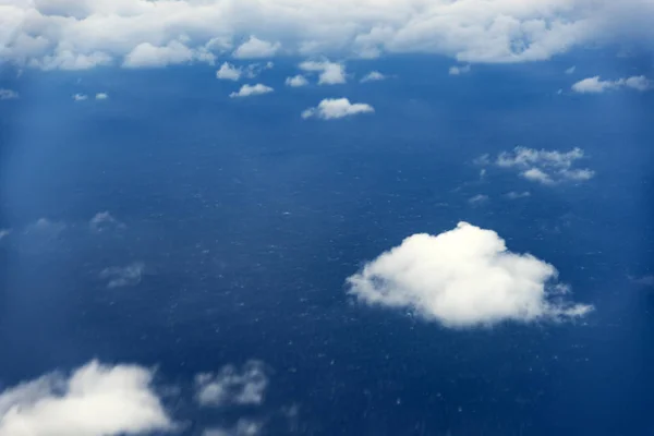 Clouds from a window of a commercial plane with sea. — Stock Photo, Image