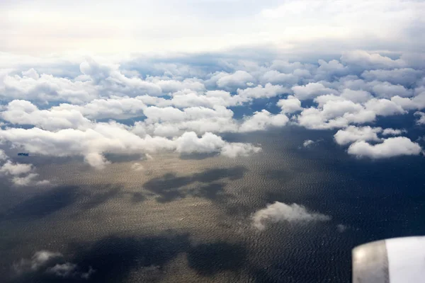 Nuages d'une fenêtre d'un avion commercial avec mer et quelques shi — Photo