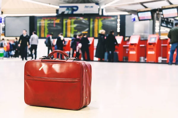 Woman with boots, coat and a red bag in an airport. — Stok fotoğraf