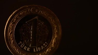 Bir Türk Lirası Sikke siyah bir arka plan üzerinde dönüyor.