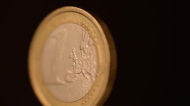 Bir Euro Coin siyah bir arka plan üzerinde dönüyor.