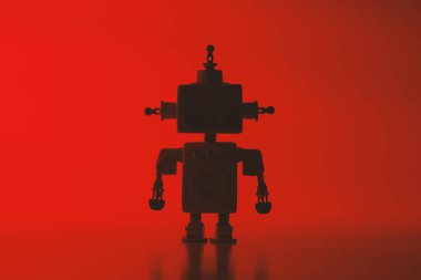 Kırmızı arka plan üzerinde sevimli bir robot silueti.
