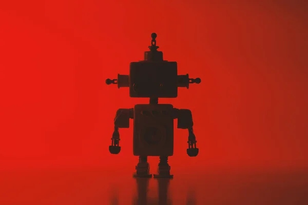 赤い背景にかわいいロボットのシルエット. — ストック写真