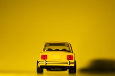 Sarı bir oyuncak arabanın arka görüntüsü.