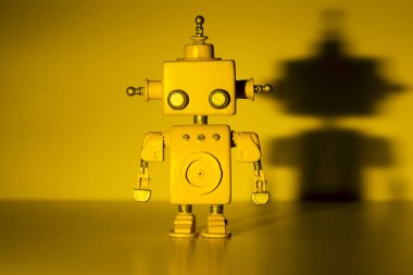 Sarı arka planda robot.