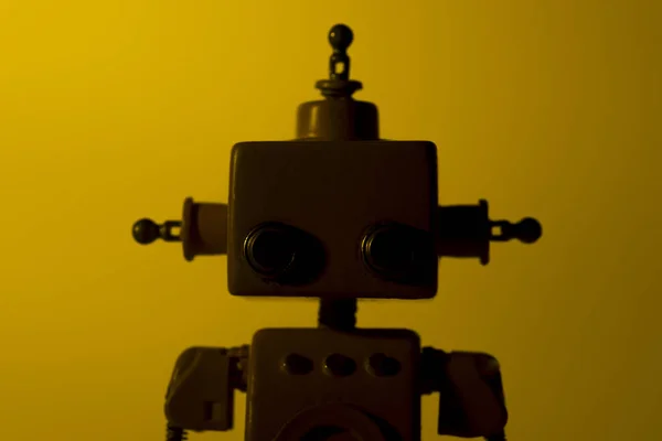 Silueta roztomilý robot na žlutém pozadí. — Stock fotografie