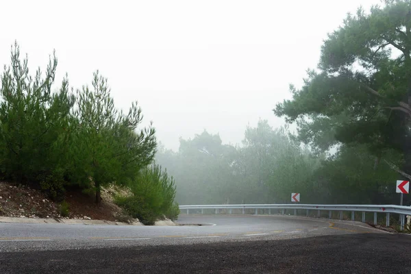 在多雾的天气里弯弯曲曲的道路的斜坡. — 图库照片