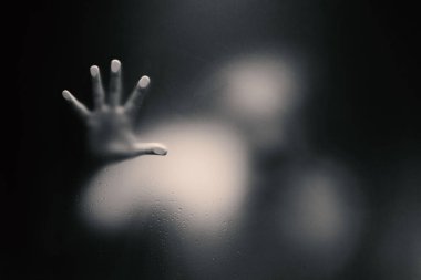 Tek elle buzlu cam tutan ürpertici adam.