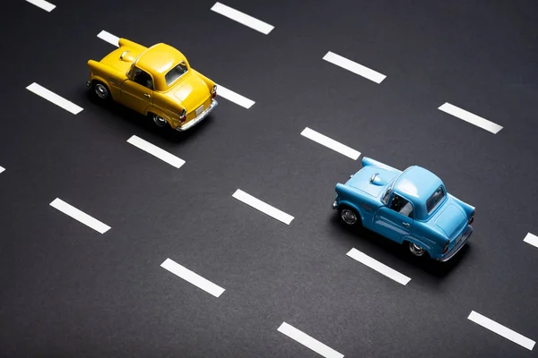 Twee speelgoed auto's op de weg een na de andere. — Stockfoto