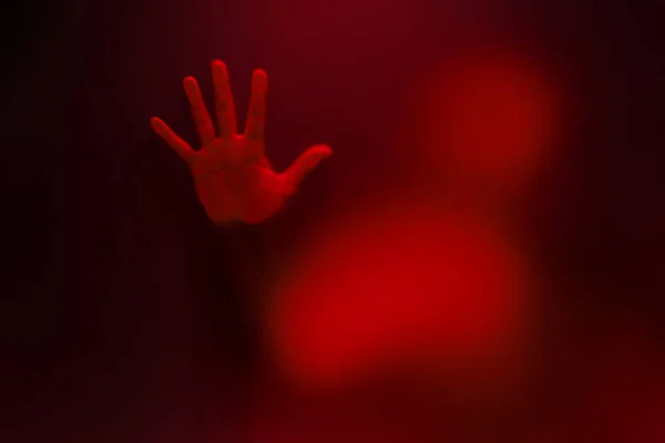 Red color version of Creepy man holding the frosted glass with o — Stock Photo, Image