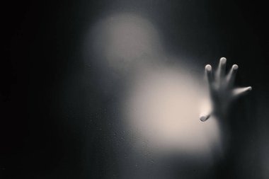 Tek elle buzlu cam tutan ürpertici adam.