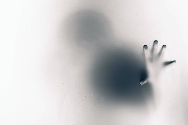 Tek elle buzlu cam tutan ürpertici adam.