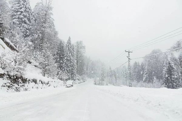 Carretera nevada en invierno con un SUV aparcado . — Foto de Stock