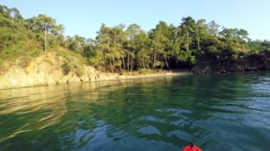 Gündüz vakti Gunluklu plajı Fethiye Mugla Türkiye 'de kıyıdan karşıya geçen ilk kişi kanoyu görür.