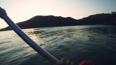 Akşamleyin Gunluklu plajı Fethiye Mugla Türkiye 'de kıyıdan karşıya geçen ilk kişi kanoyu görür.