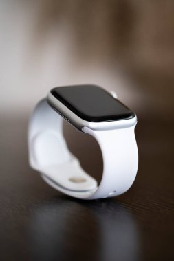İzmir, Türkiye - 7 Ağustos 2020: Tahta masadaki beyaz renkli Apple Watch 5 'in yakın çekimi.