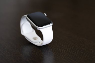 İzmir, Türkiye - 7 Ağustos 2020: Tahta masadaki beyaz renkli Apple Watch 5 'in yakın çekimi.