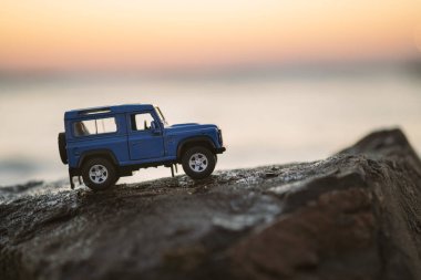 İzmir, Türkiye - 22 Ağustos 2020: Bir kayanın üzerinde ve gün batımında Land Rover SUV aracının yakın çekimi.