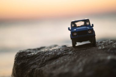 İzmir, Türkiye - 22 Ağustos 2020: Bir kayanın üzerinde ve gün batımında Land Rover SUV aracının yakın çekimi.