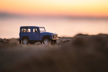 İzmir, Türkiye - 22 Ağustos 2020: Kumda ve gün batımında bir Land Rover SUV aracının yakın çekimi.