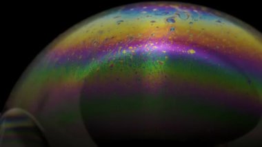 Renkli ve hareketli dokusu olan bir sabun köpüğünün yakın çekim görüntüleri.