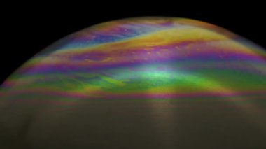 Renkli ve hareketli dokusu olan bir sabun köpüğünün yakın çekim görüntüleri.