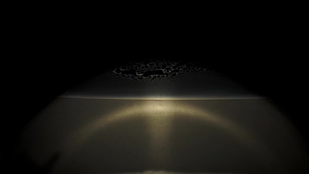 泡の表面と黒の背景の上を動き回る金色の形 — ストック動画