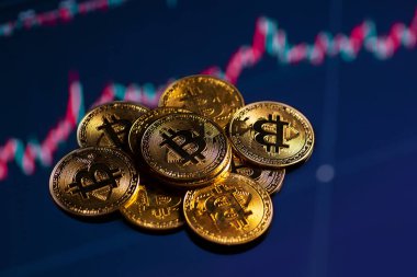 Bitcoin altın sikkelerinin yakın plan çekimleri artmakta olan grafiksel arka plan üzerinde.