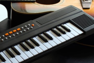 Gitarın arka planında çocukların elektronik piyanosu var.