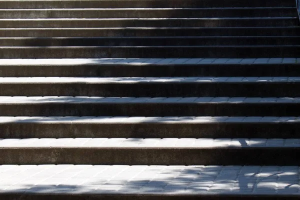 steps of a granite staircase lit by the sun