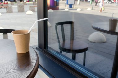 Penceresinde yansıması olan bir masanın üzerinde bir fincan kahve.