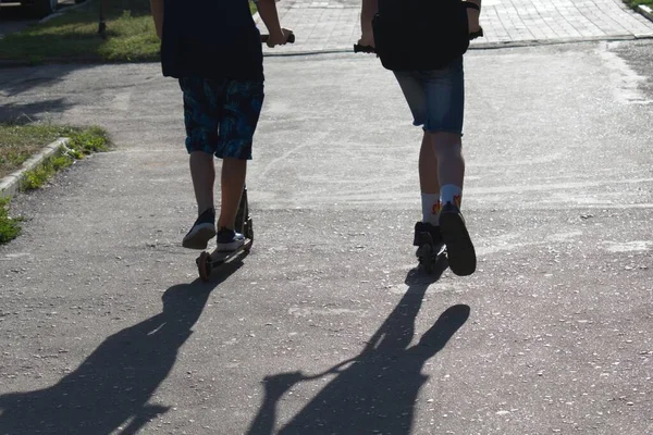 Shadows Catch Boys Scooters — стоковое фото