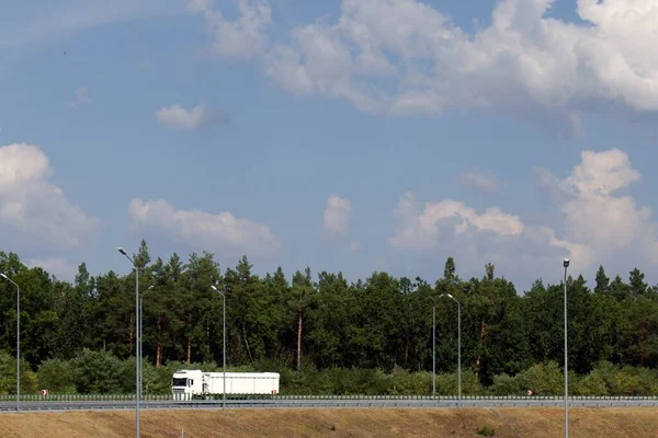 Biały Samochód Ciężarowy Wiadukcie Tle Zielonego Lasu Błękitne Niebo Białymi — Zdjęcie stockowe