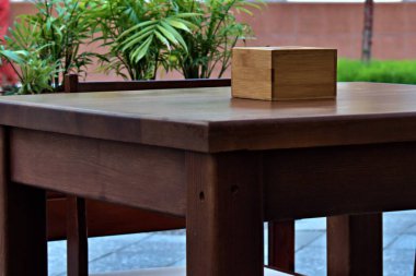 Açık kafedeki ahşap sehpanın üzerinde peçeteler olan tahta kutu.