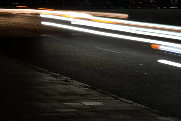 headlights of cars on city road at night in blurred motion