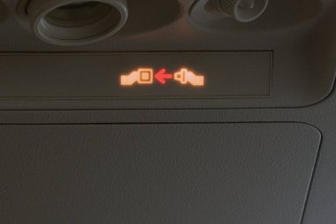 Uçaktaki yolcu koltuklarının üstündeki ışıklı ışığı açın. Emniyet kemerlerinizi bağlayın.