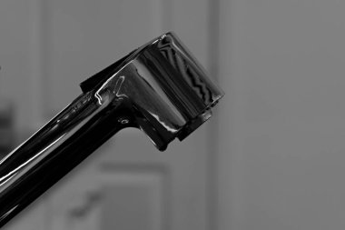 Parlak krom kaplama musluğun başı kapalı pozisyonda su olmadan güzellik salonunun beyaz bulanık arka planında. Metin için boşluk