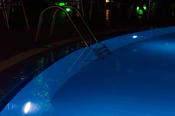 pool with multicolored lighting and reflection of lights in the water