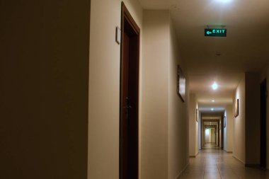 Bir sürü kapısı ve çıkış işareti olan uzun bir iç koridor.