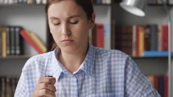 Chica tomando pastillas. Mujer de cerca escribiendo en el teclado del ordenador portátil, se separa del trabajo para tomar la porción de medicamentos en tabletas de un vial pequeño — Vídeo de stock