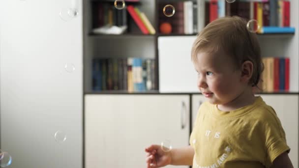 Baby verheugt zich in vallende zeepbellen — Stockvideo