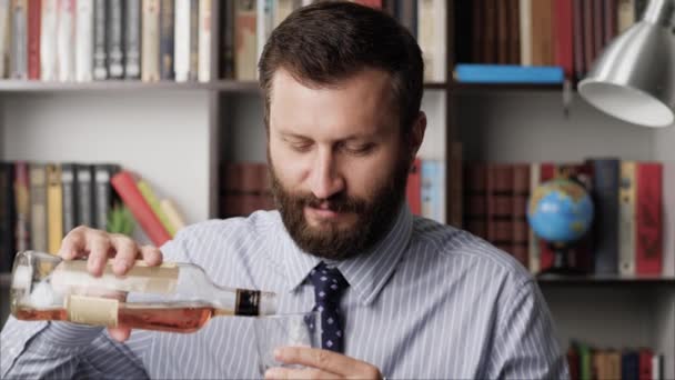 Brindisi, dipendenza da alcol, alcolismo, sbornia, concetto di festa. Un bell'uomo barbuto sorridente versa nel bicchiere una bevanda alcolica di brandy whisky scotch bourbon, guardando il toast della telecamera. Primo piano — Video Stock